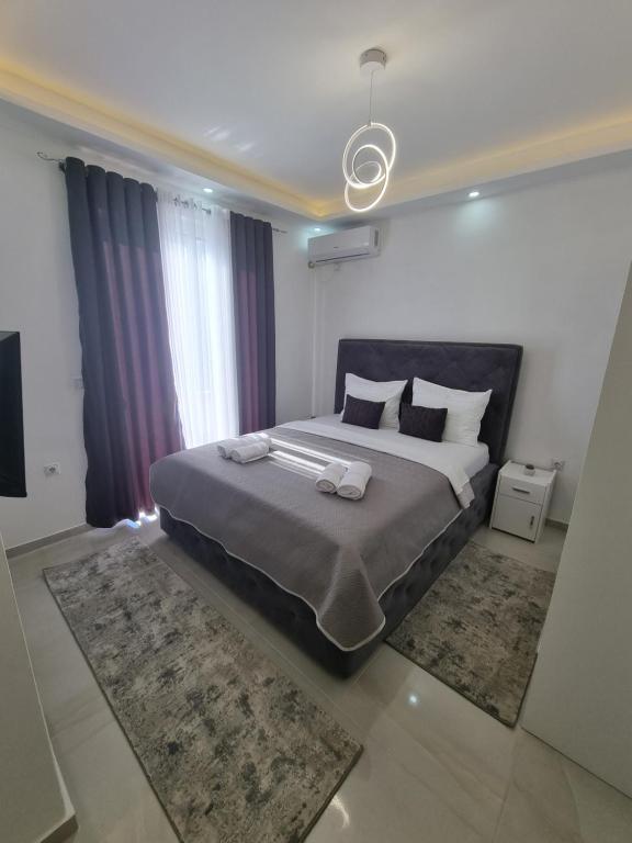 a bedroom with a large bed with two towels on it at Kahari Apartments in Ulcinj
