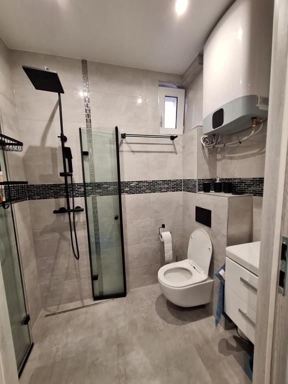 uma casa de banho com um WC e uma cabina de duche em vidro. em ,,APARTAMENT W DUSZNIKACH,, em Duszniki Zdrój