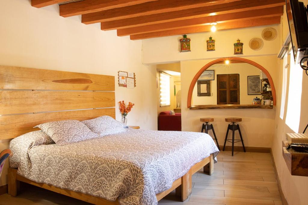 a bedroom with a bed with a wooden headboard at Lofts Las Cuatro Puertas in Guanajuato