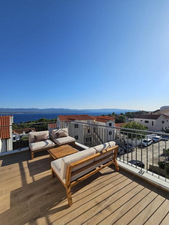 a deck with two couches and a table on a balcony at Harmony suites in Bol
