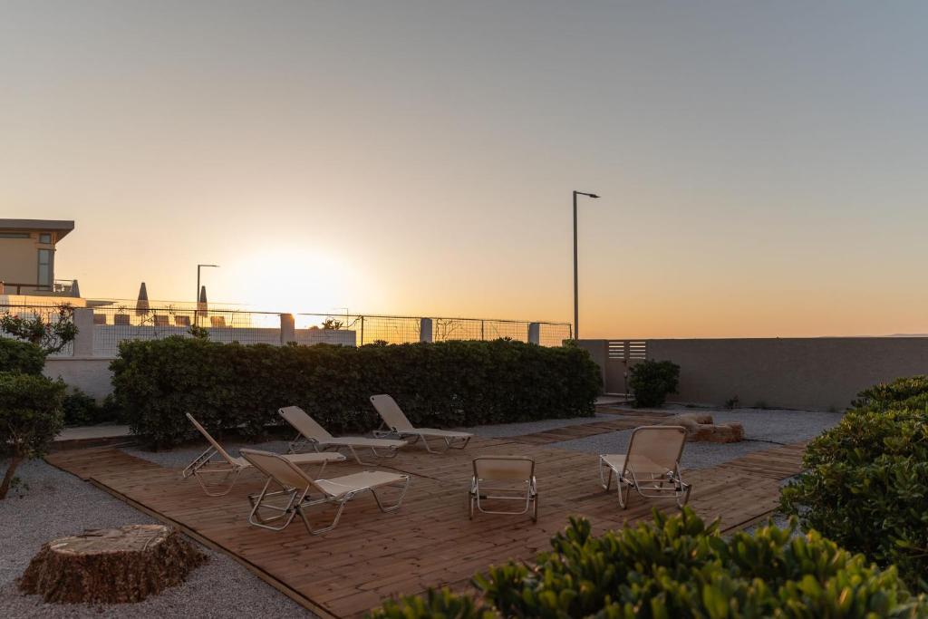 un grupo de sillas y mesas en un patio en Aelia seafront house, en Kokkíni Khánion