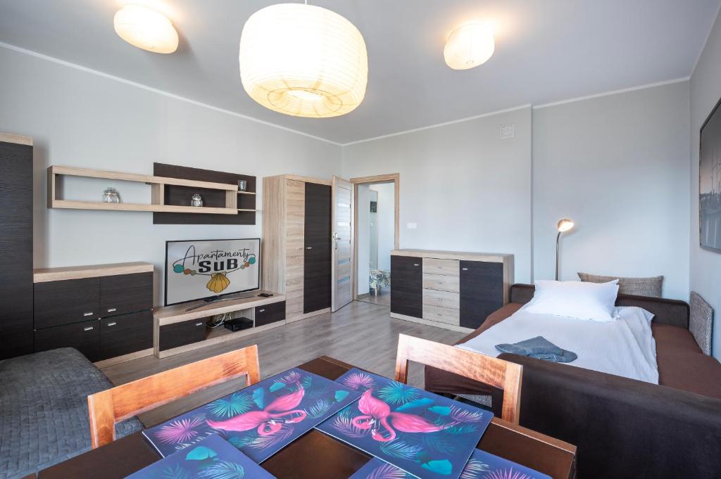 - une chambre avec un lit et une table avec des chaises dans l'établissement Apartament Sweet, à Gdynia