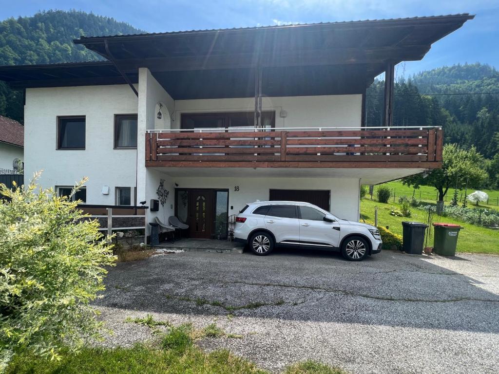 a white car parked in front of a house at FRESH Apartments in Ossiach