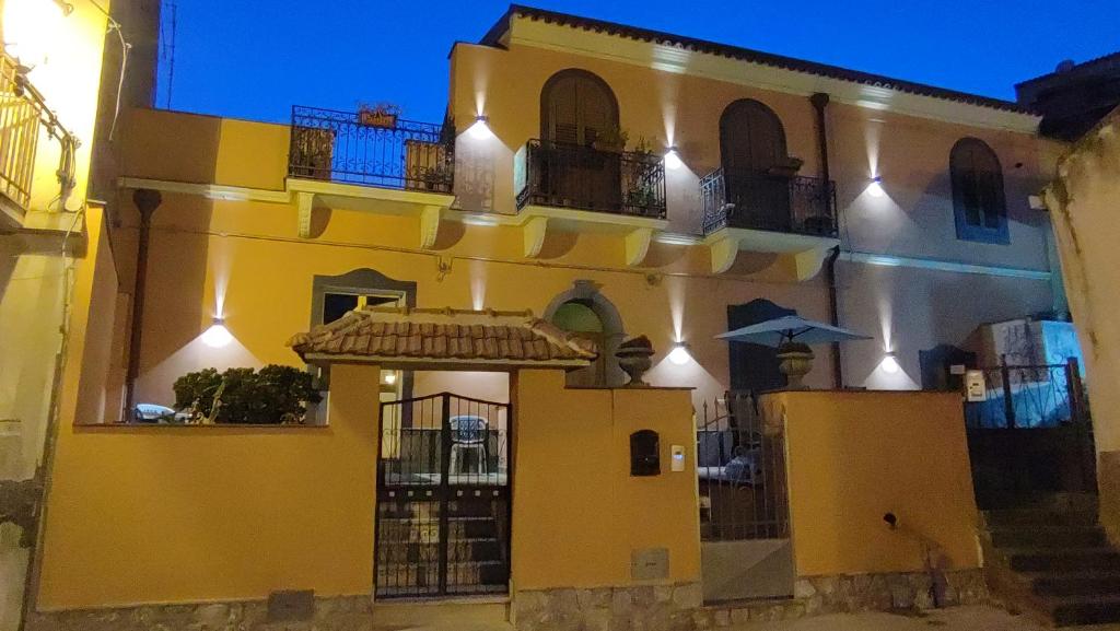 un edificio amarillo y blanco con balcones. en Sa Benedica - Luxury House, en Calatabiano