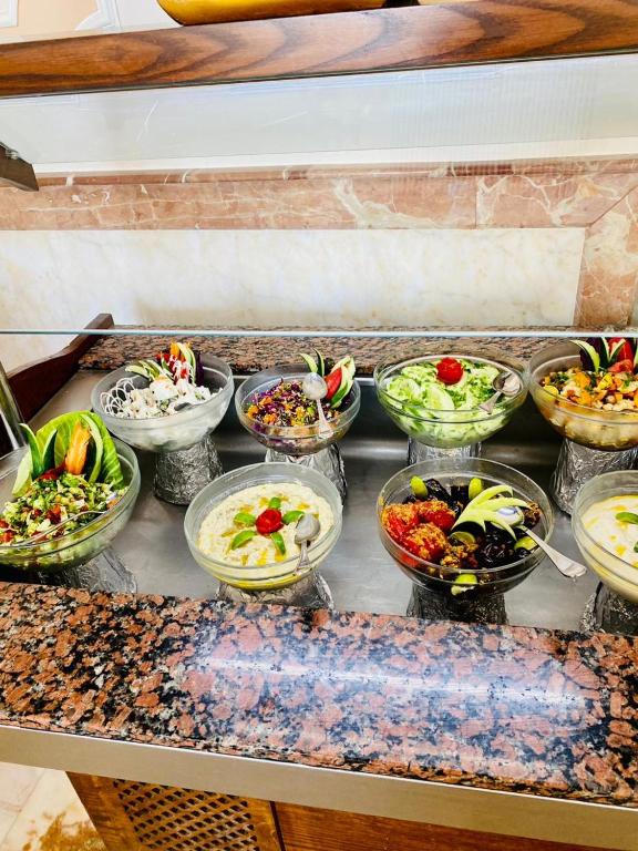 a bunch of bowls of food sitting on a counter at Tiba Rose hurghada in Hurghada