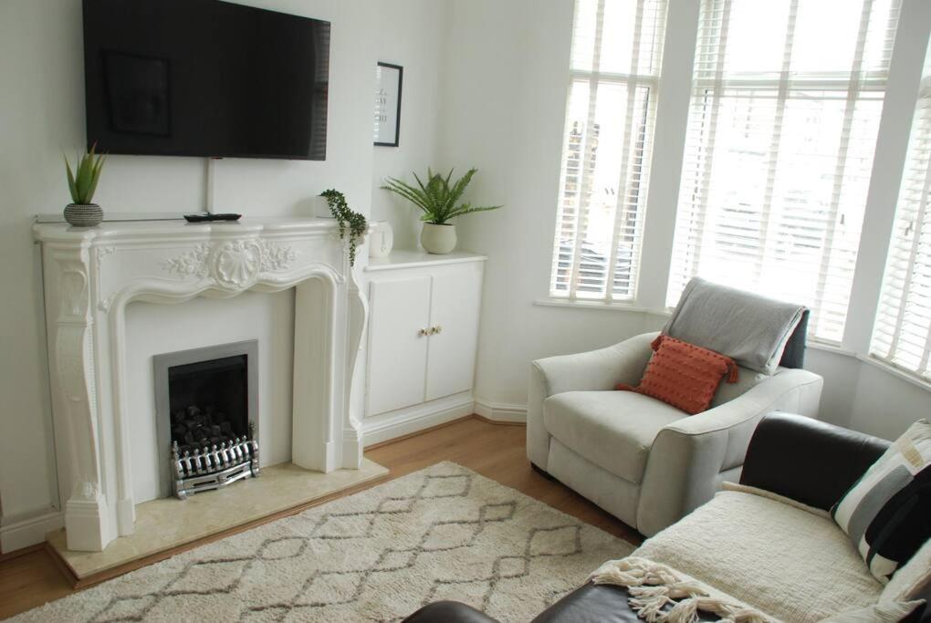 a living room with a fireplace with a tv above it at Entire house, Waterloo, free street parking in Waterloo