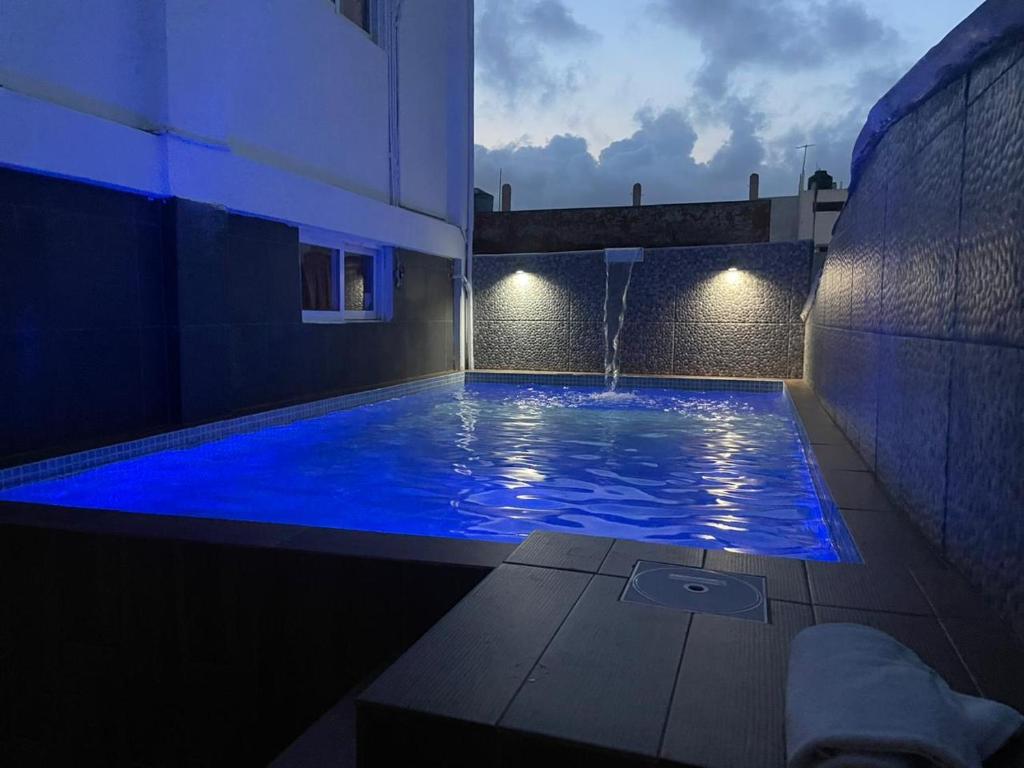 a large swimming pool with blue lighting in a building at Hotel MCH in Veracruz