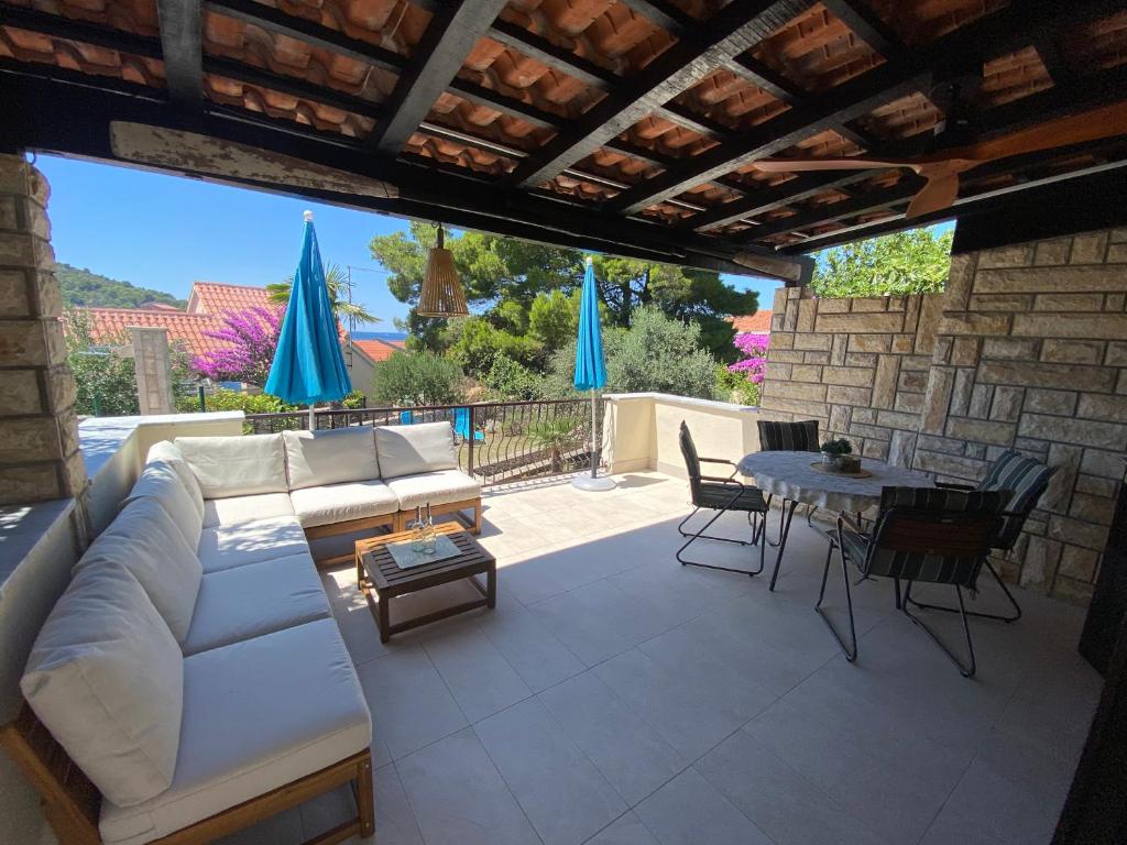 a patio with a couch and a table and chairs at Holiday House Mia in Ražanj