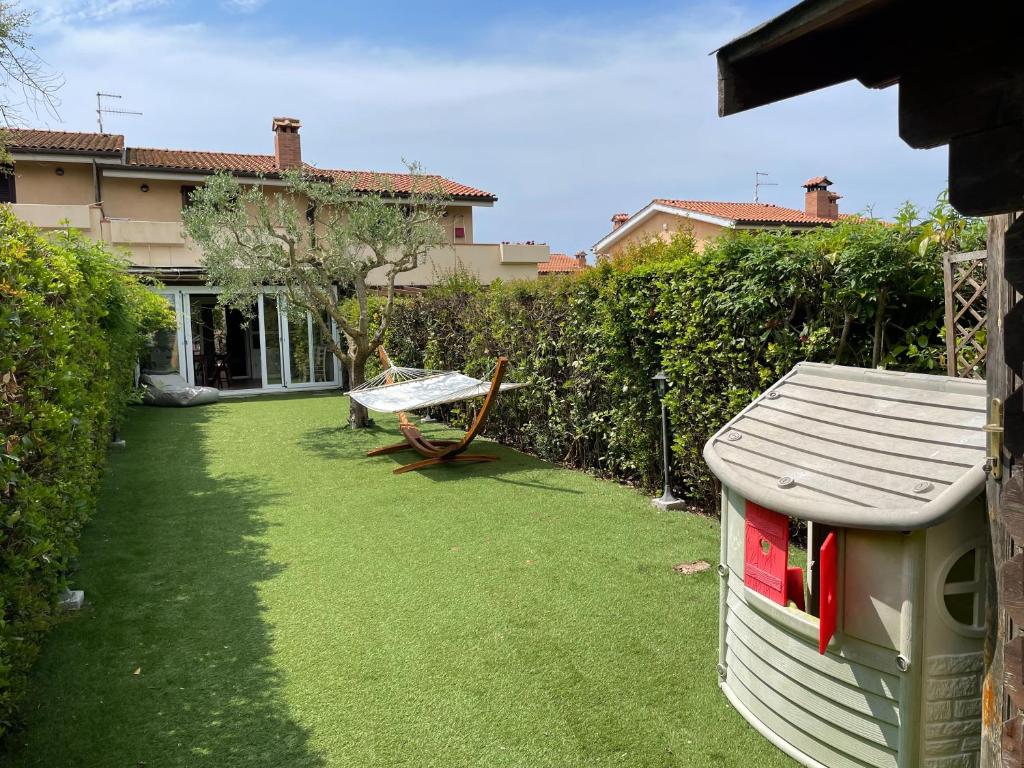 einen Hof mit einer Bank, einem Tisch und einem Haus in der Unterkunft Casa vacanza a Capalbio in Nunziatella