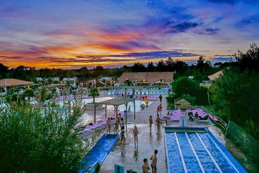 - un groupe de personnes dans un parc aquatique au coucher du soleil dans l'établissement Mobil Home 829-4 accès piscines inclus en Juillet-Aout dès 4 nuitées, à Gastes