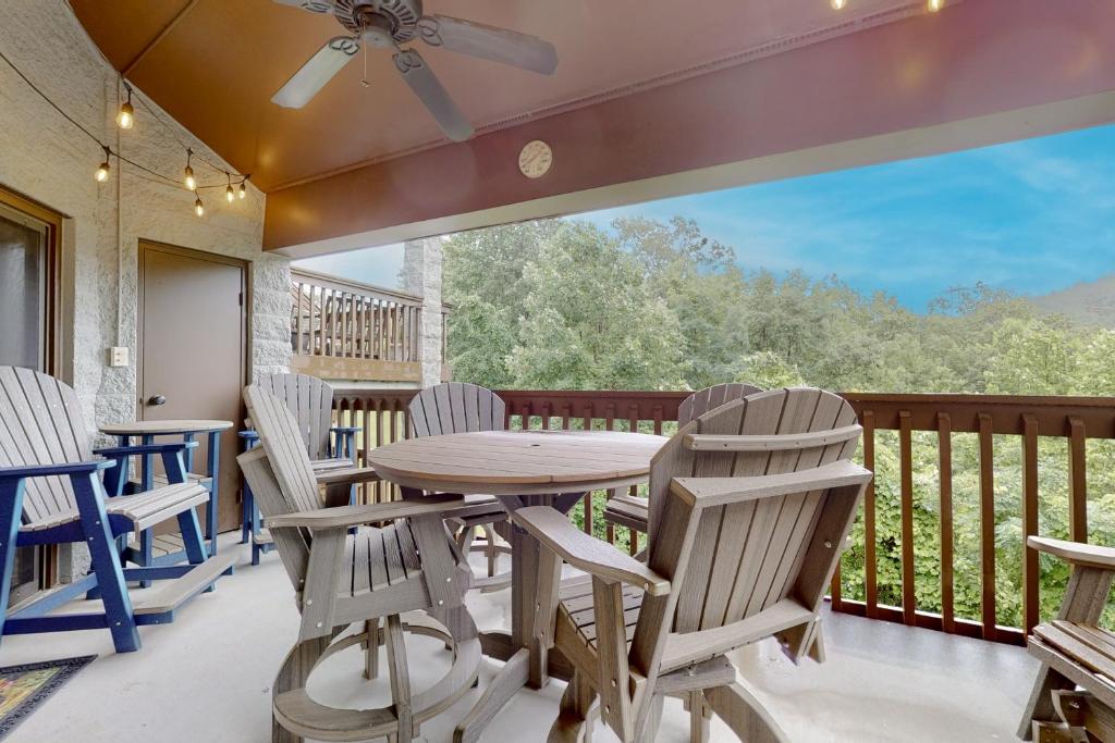 a deck with a table and chairs and a balcony at Eagles Nest Escape in Gatlinburg