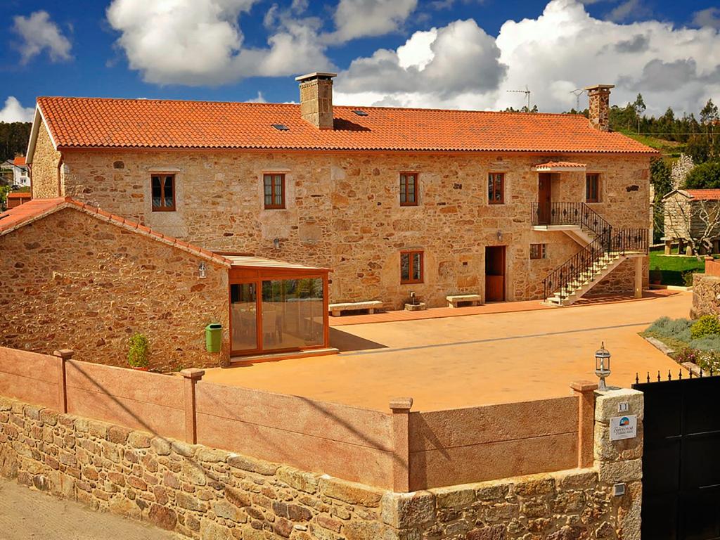 un grand bâtiment en pierre avec un mur en pierre dans l'établissement Casa Ceferinos, à Muxía