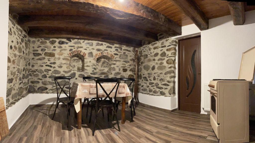 - une cuisine avec une table et des chaises dans la chambre dans l'établissement Casa de sub Salcie, à Curtea de Argeş