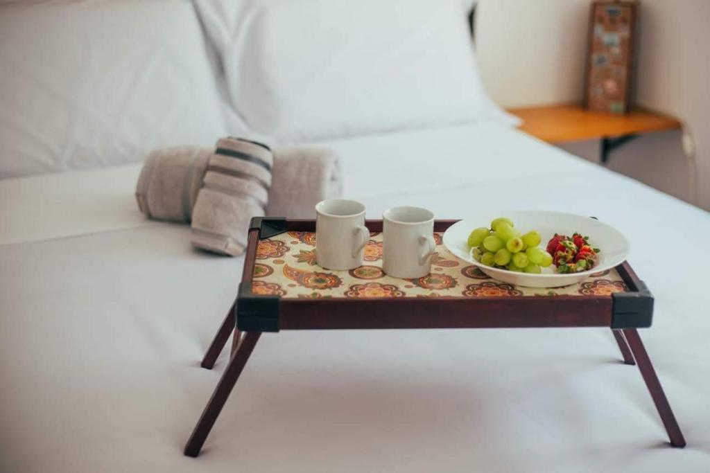 a tray with a plate of fruit on a bed at Apartamento confortável próximo ao Transamérica Expo in Sao Paulo
