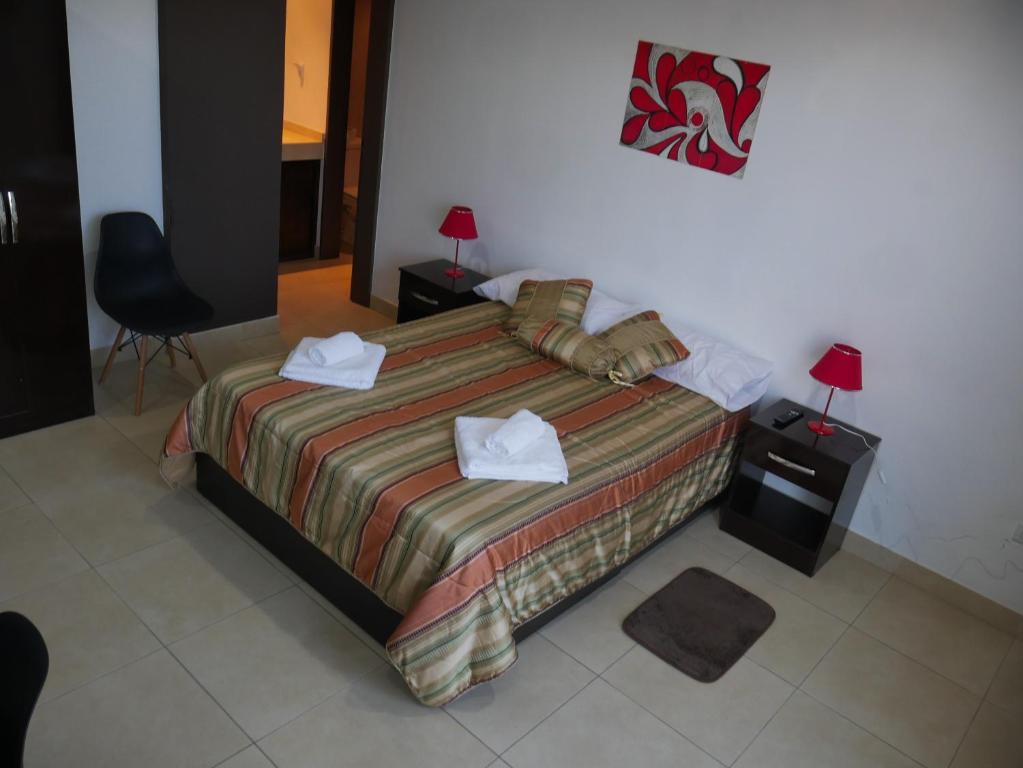 ein Schlafzimmer mit einem Bett mit zwei Handtüchern darauf in der Unterkunft Habitación Privada en Edificio de Departamentos in Salta