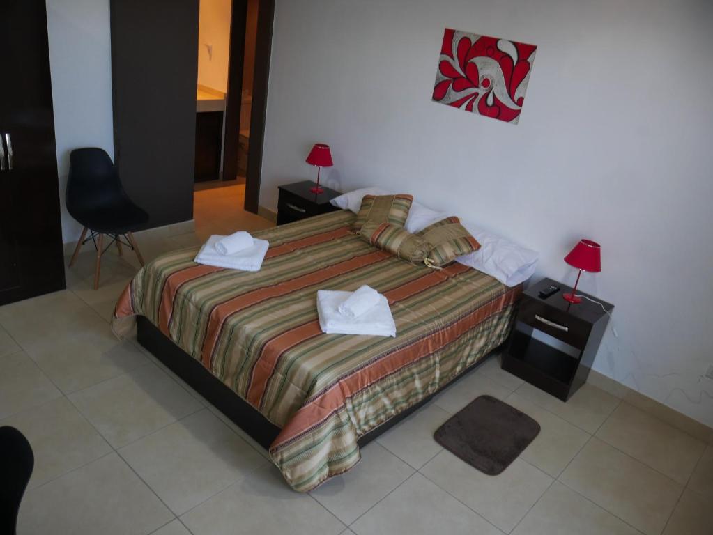 a bedroom with a bed with two towels on it at Habitación Privada en Edificio de Departamentos in Salta
