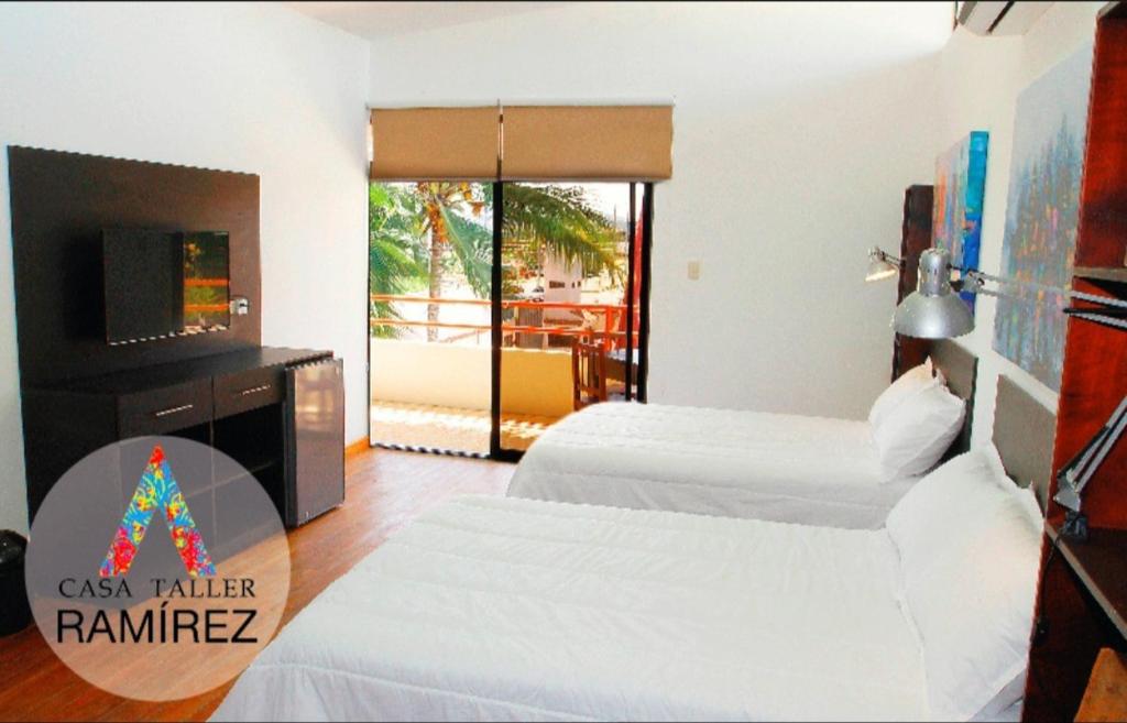 um quarto de hotel com duas camas e uma televisão em Casa Taller Ramirez em Playas