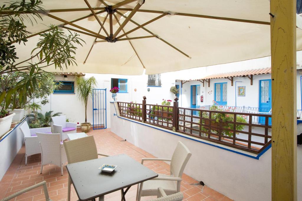 a patio with a table and chairs and an umbrella at Centrale in Trapani