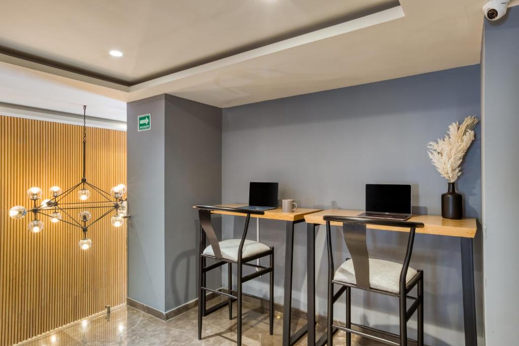 A shared work area with two high desks and individual monitors.