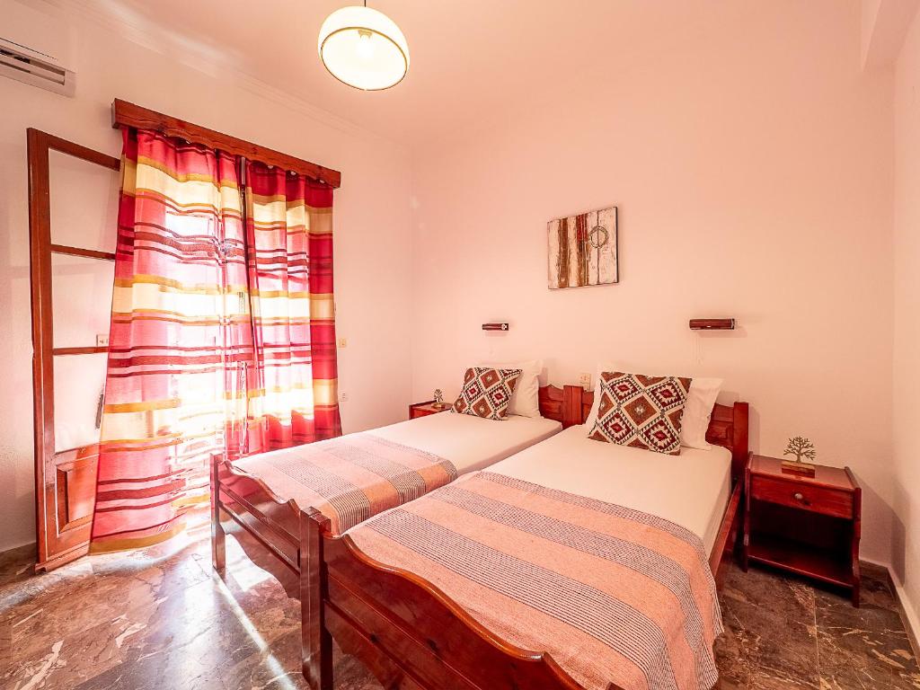 um quarto com 2 camas e uma janela em XENOFONTAS APARTMENTs em Agios Georgios Pagon