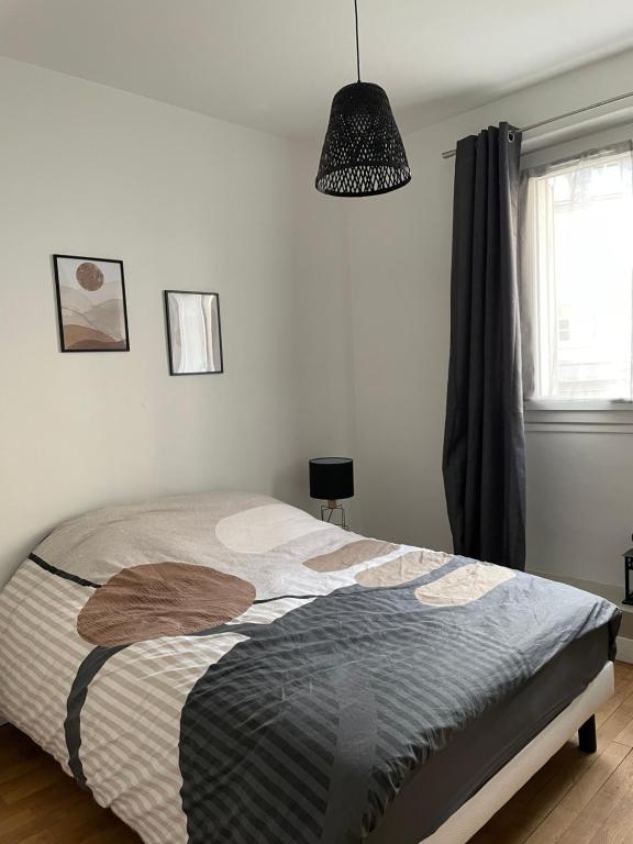 a bedroom with a bed and a pendant light at Le Cosy in Blois