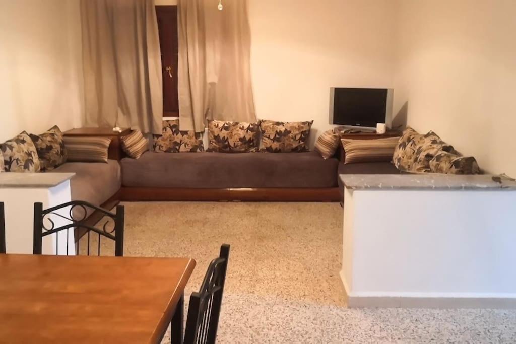 Casa Mima في تطوان: غرفة معيشة مع أريكة وتلفزيون