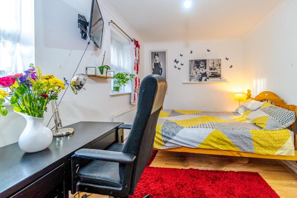 a bedroom with a desk and a bed and a table and chair at Super room with free parking 400 Mbps Internet in London