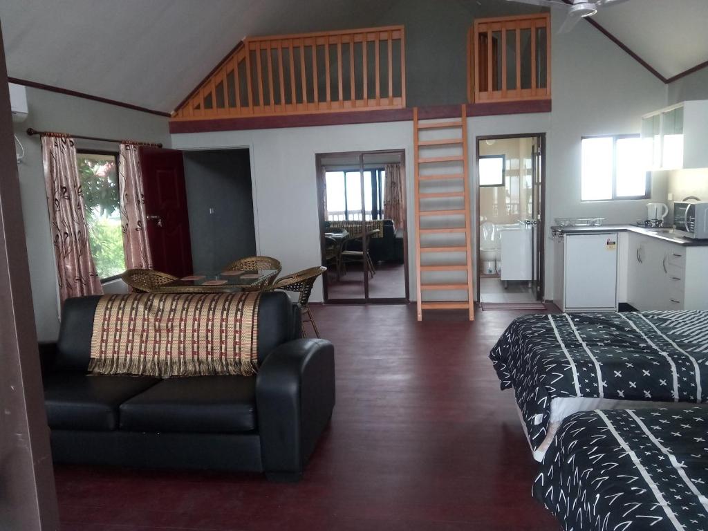 a room with two beds and a couch and a kitchen at Seaside Villa in Singatoka