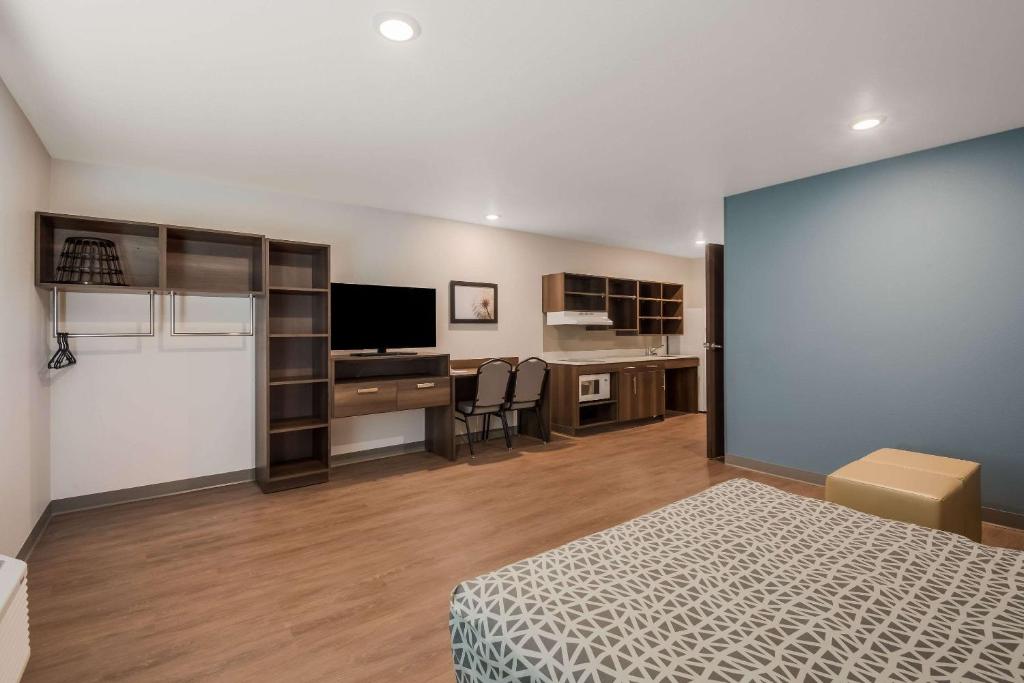sypialnia z łóżkiem i biurkiem z telewizorem w obiekcie WoodSpring Suites Bellflower - Los Angeles w mieście Bellflower
