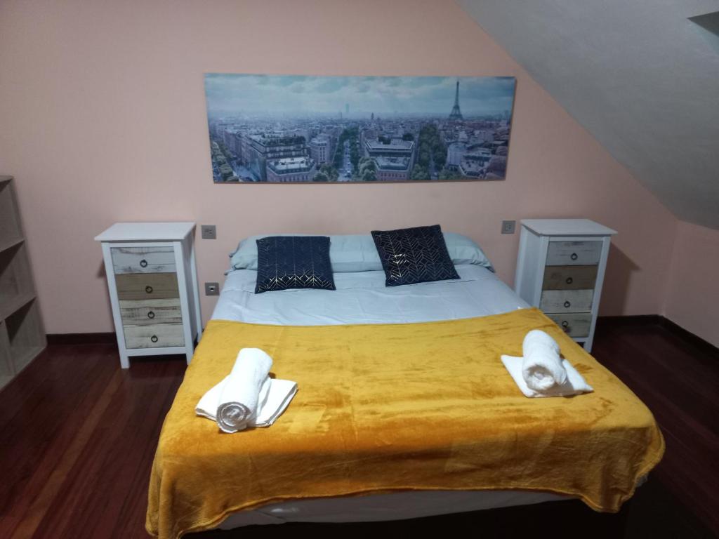 ein Schlafzimmer mit einem großen Bett mit Handtüchern darauf in der Unterkunft Meda hogar in Caldas de Reis