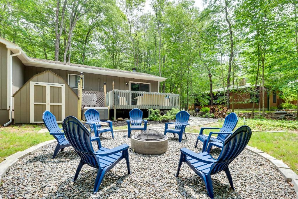 a group of blue chairs sitting around a fire pit at Cozy Gouldsboro Home with Fire Pit in Big Bass Lake! in Gouldsboro