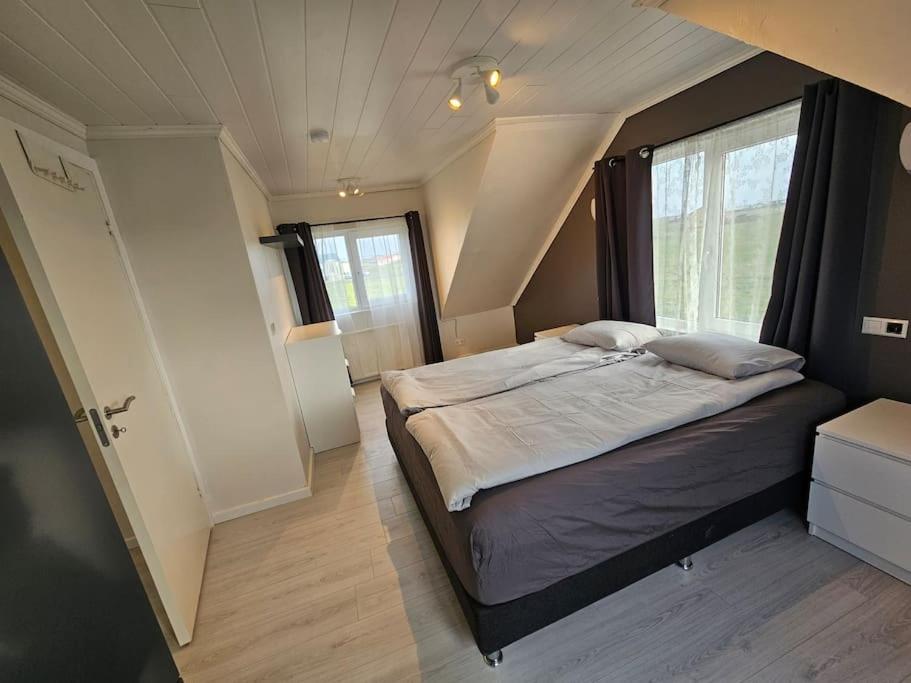 ein Schlafzimmer mit einem Bett in einem kleinen Zimmer in der Unterkunft VOT Vacation Homes-Akurhús in Gardur