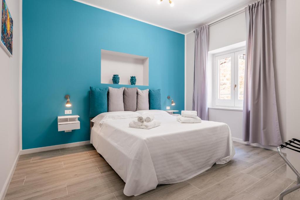 Dormitorio azul con cama grande y pared azul en LE PORTE DEL KASSARO, en Palermo