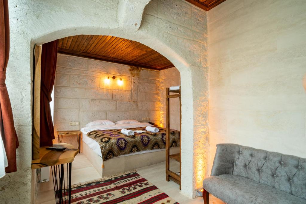 um quarto com uma cama numa parede de pedra em Cappadocia Snora Cave em Nevşehir