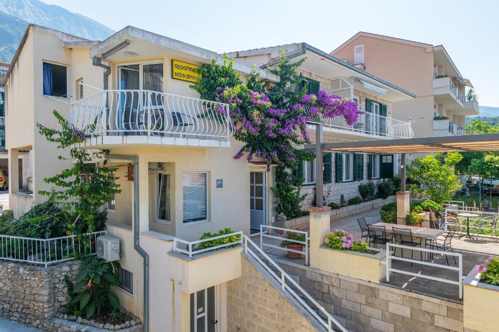 a house with flowers on the balconies of it at Apartments with a parking space Tucepi, Makarska - 6856 in Tučepi