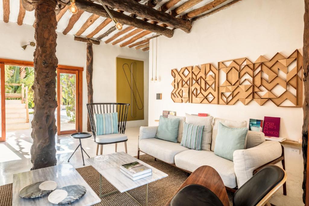 a living room with a couch and a table at Ser Casasandra Boutique Hotel in Holbox Island