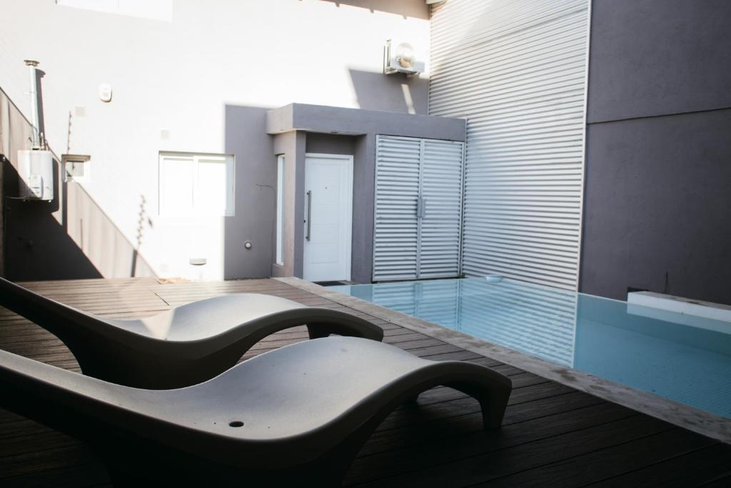 una piscina con un banco en un edificio en Tempo Apartamento en Villa Allende