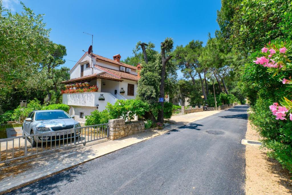 a house with a car parked on the side of a road at Apartment Artatore 2509a in Čunski