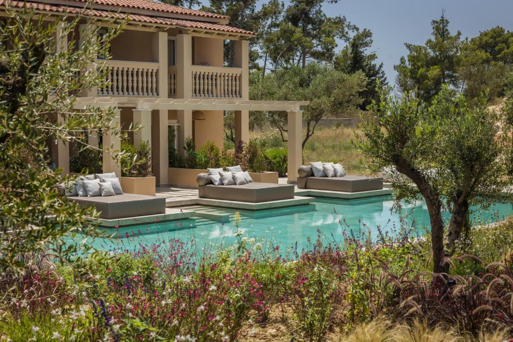 a villa with a swimming pool and a house at Thalassa Boutique Hotel - Adults Only in Lassi