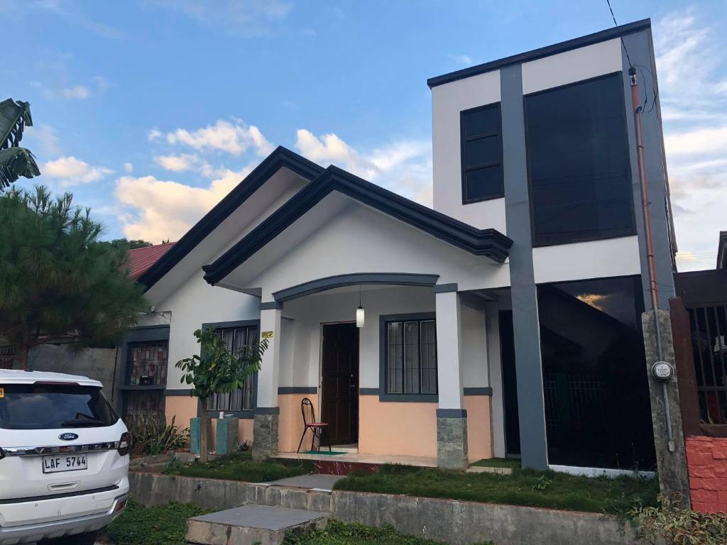 een witte auto geparkeerd voor een klein huis bij Air-conditioned Home in Davao City