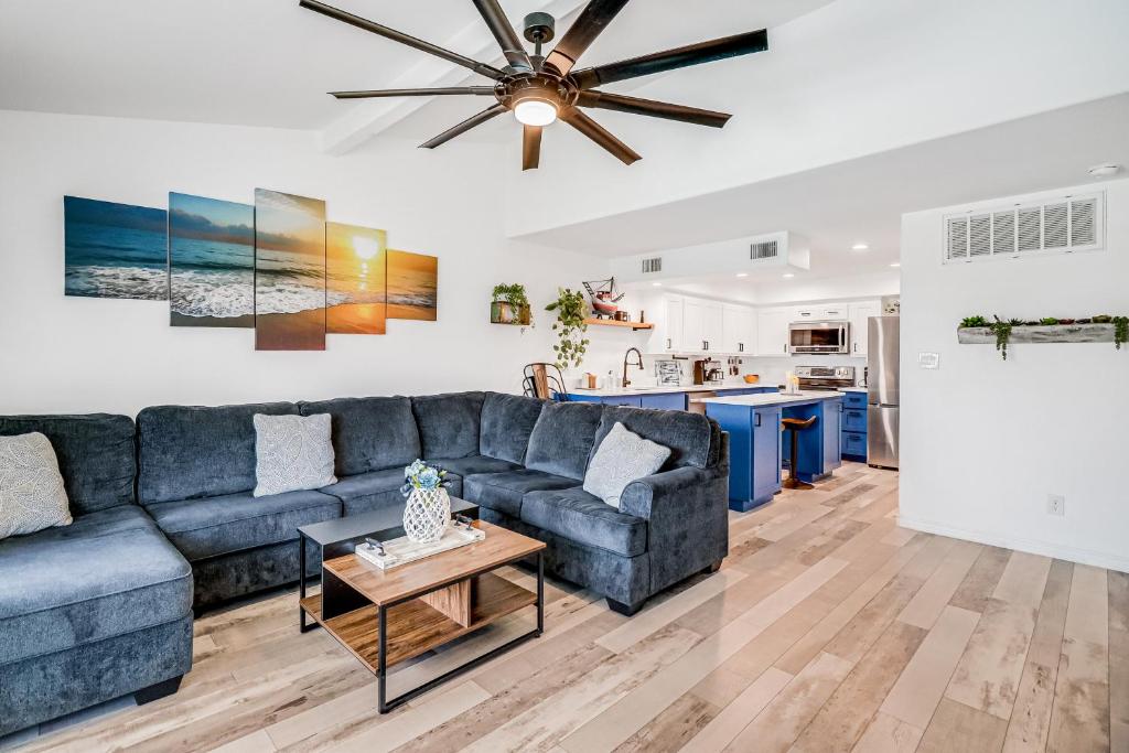 a living room with a blue couch and a ceiling fan at Nassau #402 in Rockport