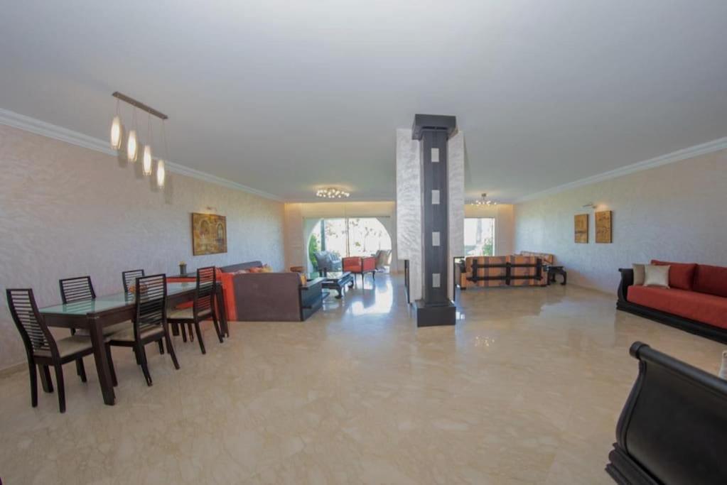 a large living room with a table and chairs at Bord de mer, villa de luxe in Tamaris