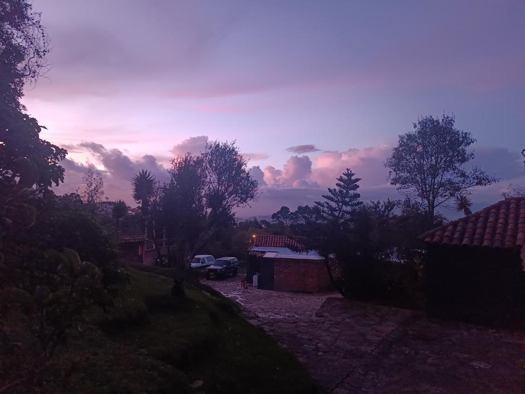 a view of a sunset with cars parked in a yard at Casa Indigena de la Paz Shinawindua in Bogotá