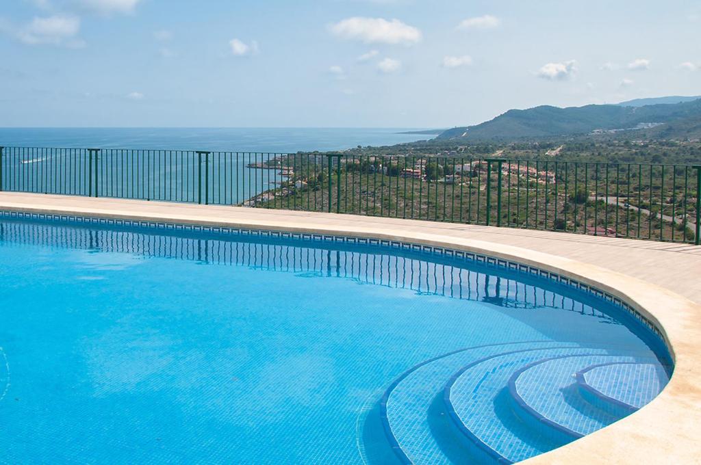 a large swimming pool with a view of a city at Ítaca Apartment Peñiscola in Peñíscola