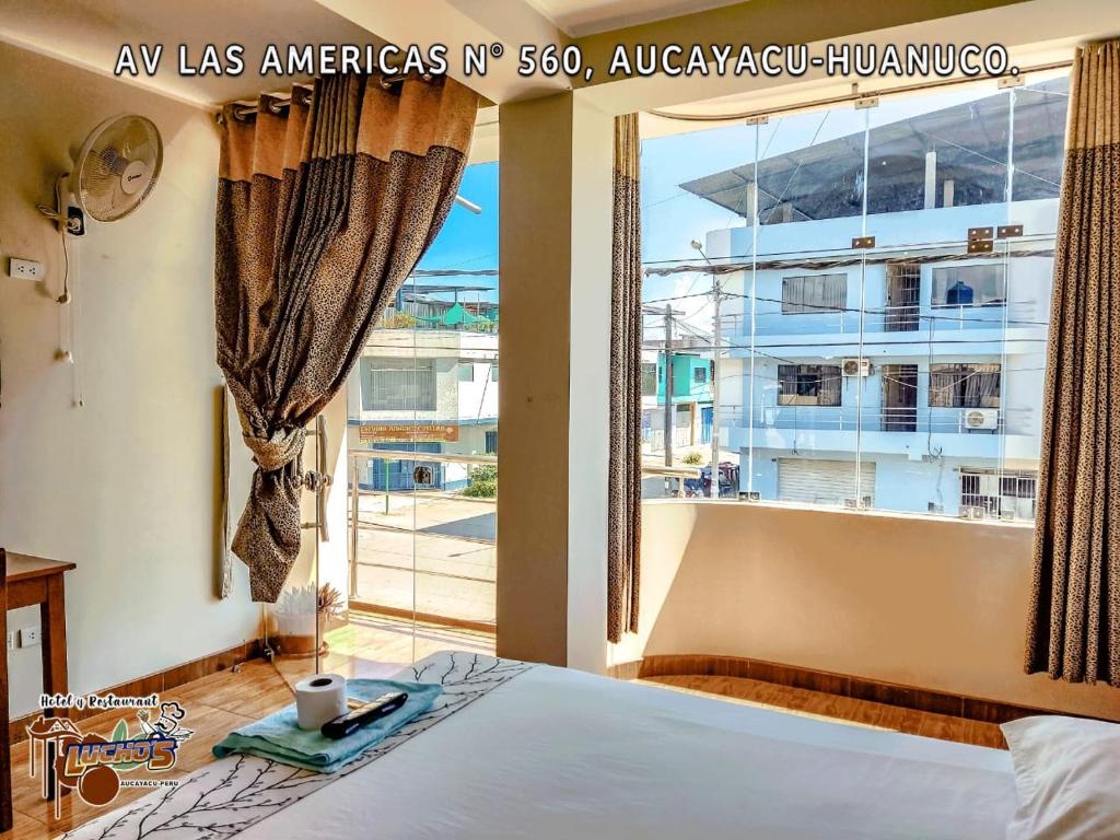 um quarto com uma cama e uma grande janela em HOTEL LUCHO'S em Aucayacu