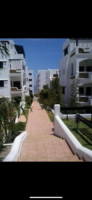 a walkway in a city with white buildings at Duplex à oued Laou in Oued Laou