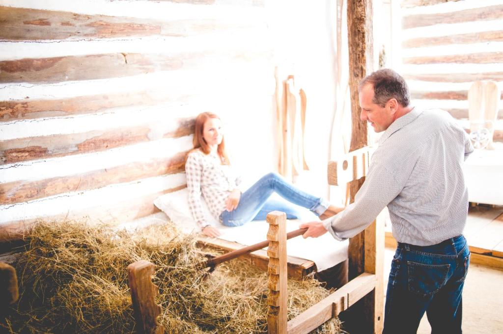 Um homem a apertar a mão a uma mulher num celeiro. em Faluhely Major em Mátranovák