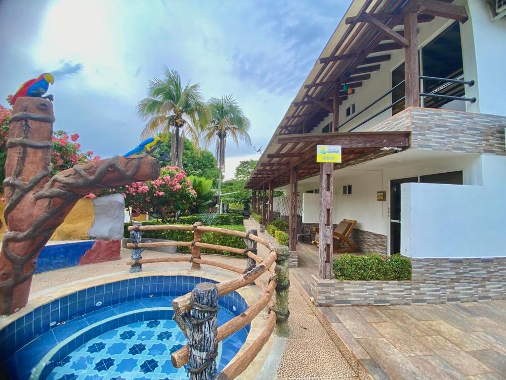 a pool in front of a house with a water slide at Finca Hotel California Doradal in Doradal
