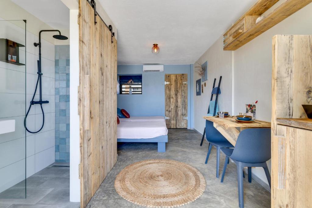 a bathroom with a shower and a bedroom with a bed at The Hut Bonaire in Kralendijk