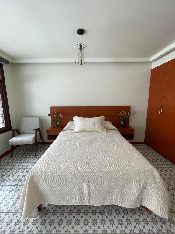 a bedroom with a large bed and a chair at Casa Sol in Oaxaca City